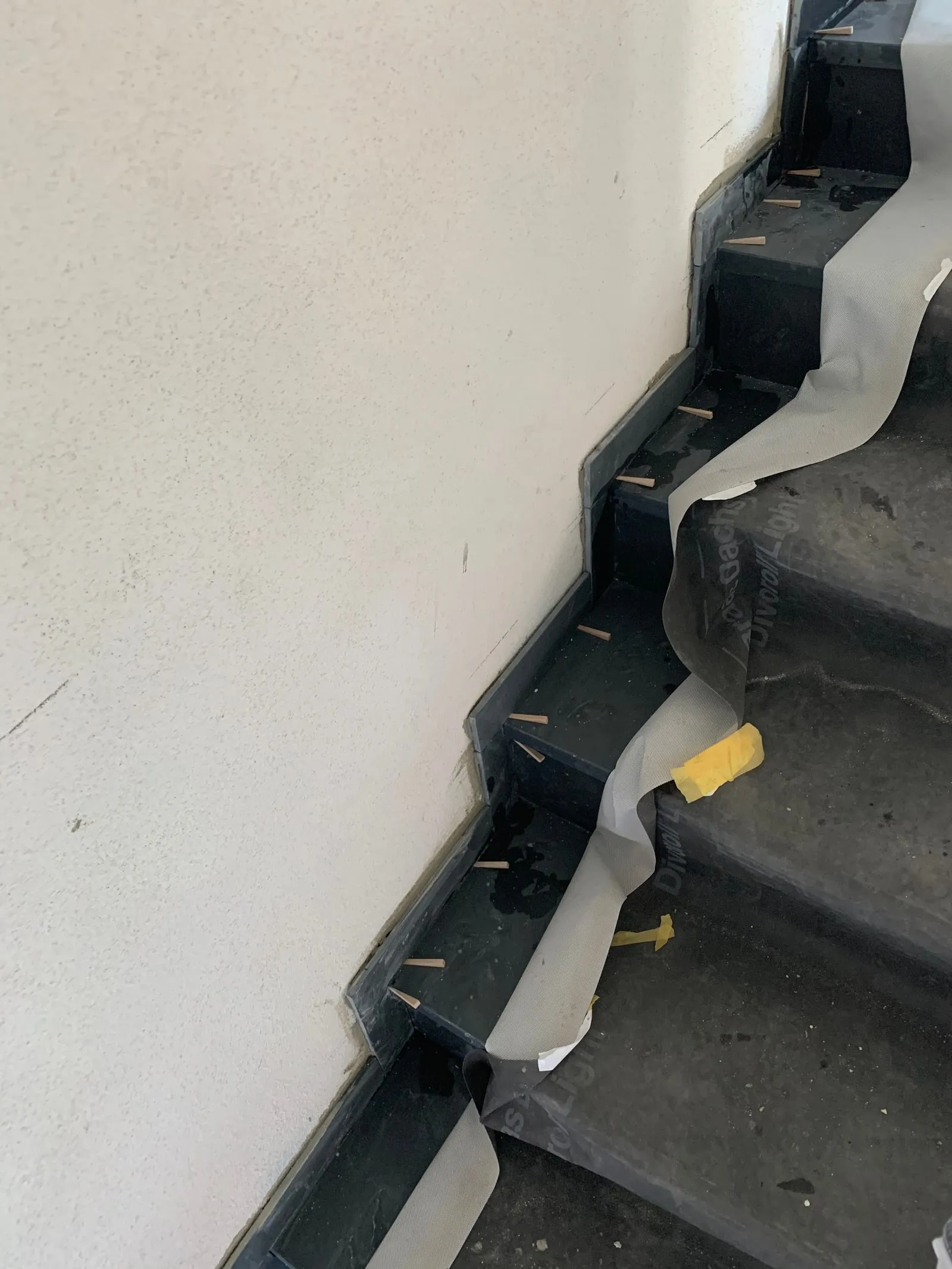 Detail einer Treppe mit dunklen Naturstein-Stufen während des Einbaus