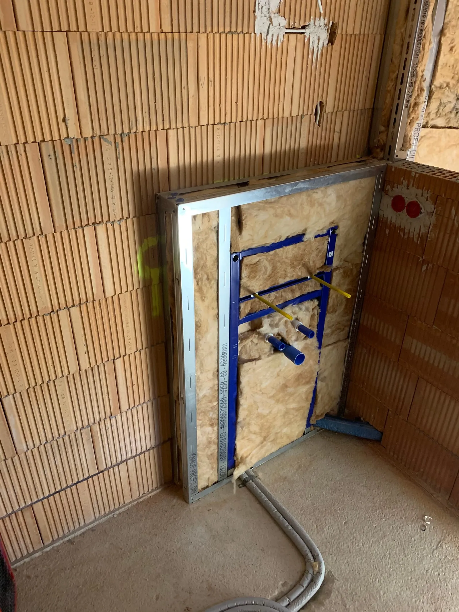 Gedämmte Installationsebene mit Vorwandelement vor einer Ziegelwand, bereit zur Beplankung